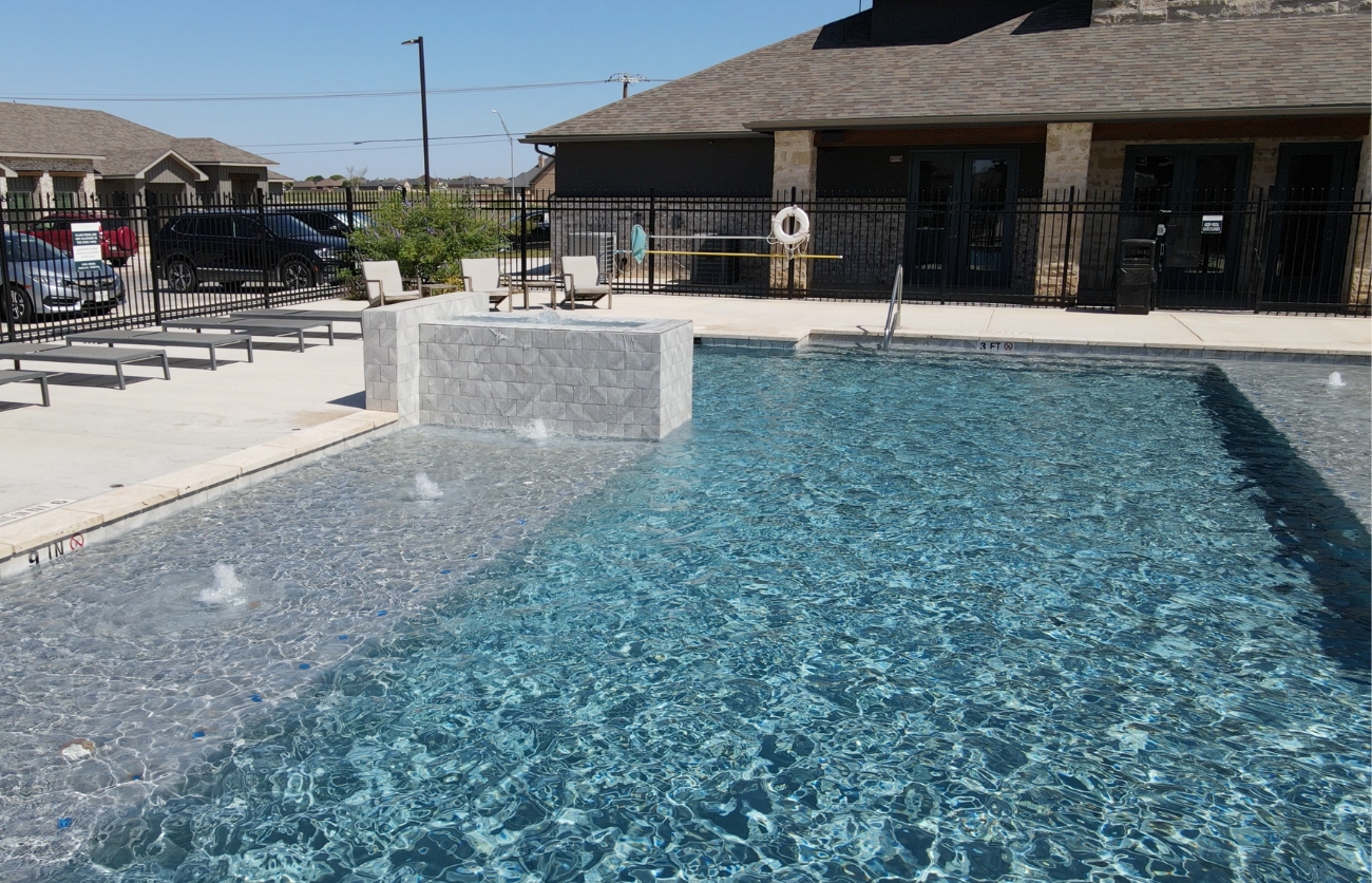 Luxury outdoor pool area at The Leighton Apartments in Lubbock, Texas.